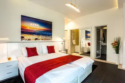 a bedroom with a large bed with a painting on the wall at Complex Europe in Dolna Banya