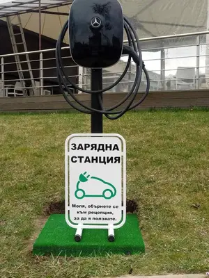 a sign in the grass in front of a building at Complex Europe in Dolna Banya