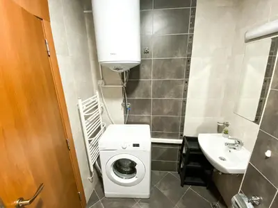 a small bathroom with a washing machine and a sink at Evergreen Private Apartment 303 in Bansko