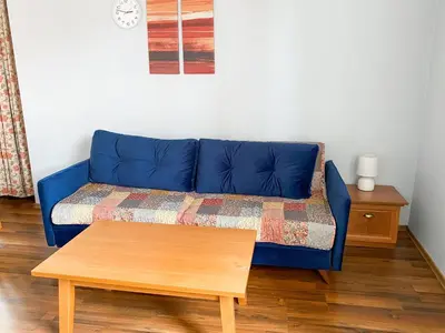 a blue couch in a living room with a coffee table at Evergreen Private Apartment 303 in Bansko