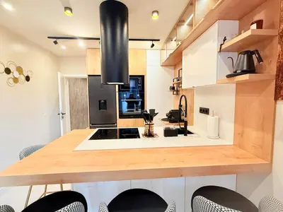 a kitchen with a wooden counter top with chairs at Lux Boutique 2 BDR apartment right next ski gondola lift in Bansko