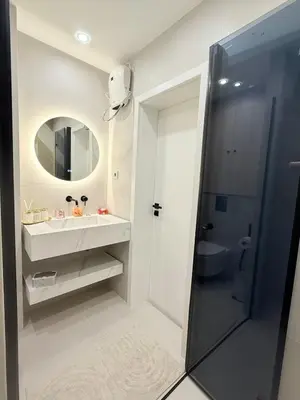 a white bathroom with a sink and a mirror at Lux Boutique 2 BDR apartment right next ski gondola lift in Bansko
