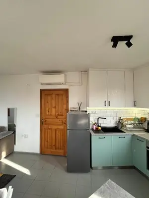 a kitchen with a refrigerator and a wooden door at Cu29 Kapana art Apartments in Plovdiv