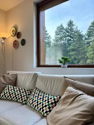 a white couch with pillows sitting in front of a window at Kosara Apartment Home2Host in Bansko