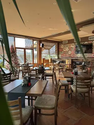 a restaurant with wooden tables and chairs and windows at Мотел КОМПЛЕКС GRILL and CHILL in Levunovo