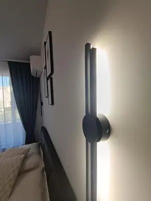 a bedroom with a bed and a lamp on a wall at Boutique apartment 4-6 in Plovdiv