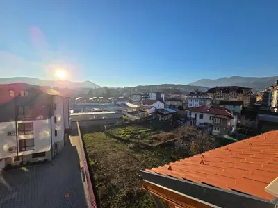 a view of a city with the sun rising over the roofs at Apartment Aria 7 in Velingrad