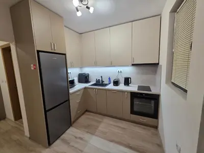 a kitchen with white cabinets and a black refrigerator at Apartment Aria 7 in Velingrad