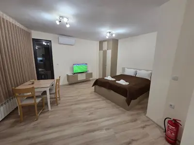 a bedroom with a bed and a table and a television at Apartment Aria 7 in Velingrad