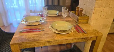 a wooden table with plates and wine glasses on it at Amore Grande in Beli Iskar