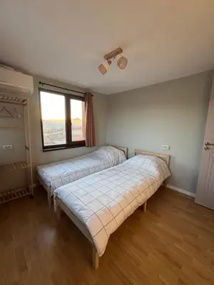 two beds in a room with a window at Къща за гости Пегас in Velingrad