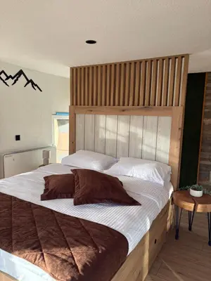 a large bed with a wooden headboard in a bedroom at Loft Chalet Bansko in Bansko