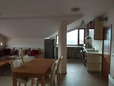 a kitchen and a living room with a table and chairs at Bansko View 3 in Bansko