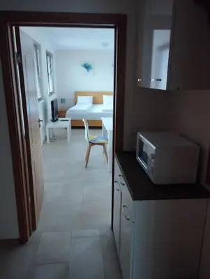 a kitchen with a microwave and a room with a bed at Bansko View 3 in Bansko