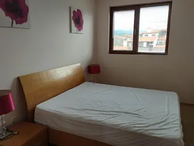 a bedroom with a white bed and a window at Bansko View 3 in Bansko