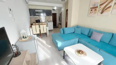 a living room with a blue couch and a table at Аpartment C103 Grand Bansko 1 in Bansko