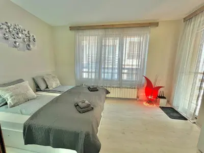 a bedroom with a bed and a couch and windows at 2BR Snowflake Stay Bansko by SI Stay in Bansko