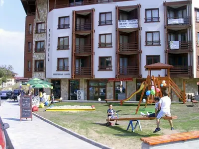 a large building with a playground in front of it at 2BR Snowflake Stay Bansko by SI Stay in Bansko