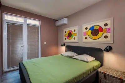 a bedroom with a green bed and a window at Plovdiv ArtNest - 1-Bedroom Cozy Apartments in Plovdiv
