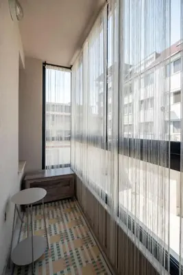 a room with a large window with two chairs and a table at Plovdiv ArtNest - 1-Bedroom Cozy Apartments in Plovdiv