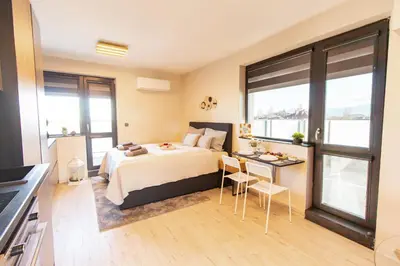 a bedroom with a bed and a table and chairs at Domus Apartments Vista in Plovdiv