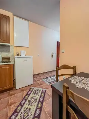 a kitchen with a white refrigerator and a table at Fireplace Apartment near Bus & Train Station in Bansko