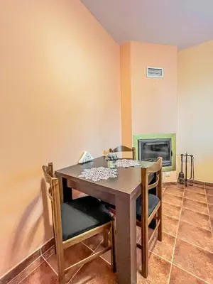 a dining room with a table and chairs and a fireplace at Fireplace Apartment near Bus & Train Station in Bansko