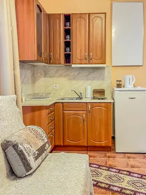 a kitchen with wooden cabinets and a white refrigerator at Fireplace Apartment near Bus & Train Station in Bansko
