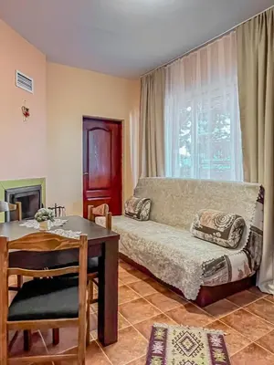 a living room with a couch and a table at Fireplace Apartment near Bus & Train Station in Bansko