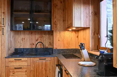 a kitchen with wooden cabinets and a sink at Cozy 1-Bedroom Apartment in St Ivan Ski Resort by Flat Mаnаger in Blagoevgrad