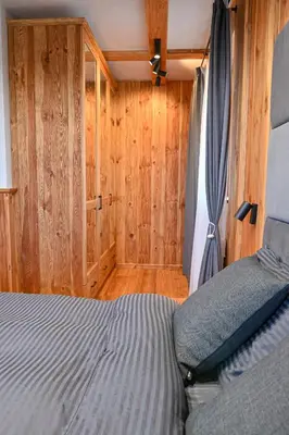 a bedroom with a bed and a wooden wall at Cozy 1-Bedroom Apartment in St Ivan Ski Resort by Flat Mаnаger in Blagoevgrad