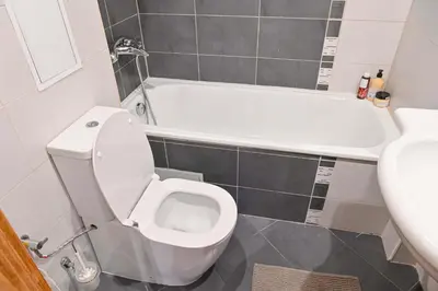 a bathroom with a white toilet and a bath tub at Cozy 1-Bedroom Apartment in St Ivan Ski Resort by Flat Mаnаger in Blagoevgrad