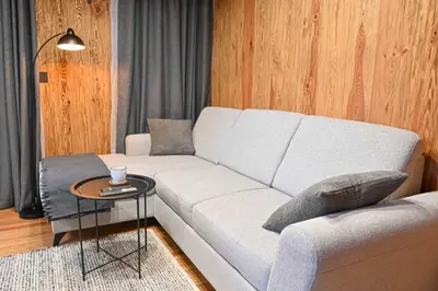 a living room with a white couch and a table at Cozy 1-Bedroom Apartment in St Ivan Ski Resort by Flat Mаnаger in Blagoevgrad