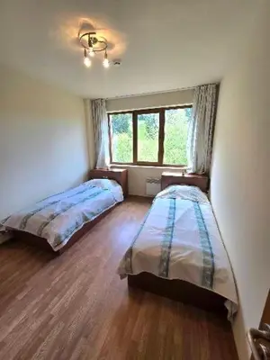 a bedroom with two beds and a window at Lucky SP apartments -Pamporovo in Bŭnzareto