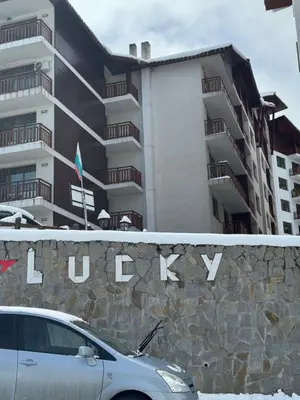 a white car parked in front of a building at Lucky SP apartments -Pamporovo in Bŭnzareto