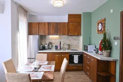 a kitchen with a table and a kitchen with a christmas tree at Comfortable 2-Bedroom Apartment Near the Ski Lift by Flat Mаnаger in Bansko