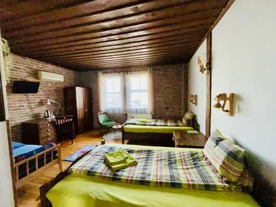 a room with a bedroom with a bed and a desk at Семеен хотел-ресторант Маламовата къща in Gotse Delchev