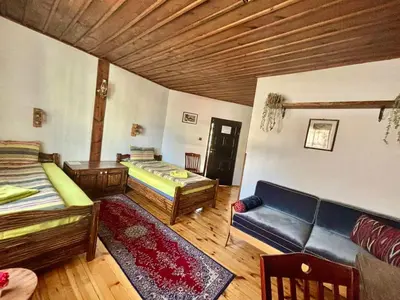 a living room with two beds and a couch at Семеен хотел-ресторант Маламовата къща in Gotse Delchev