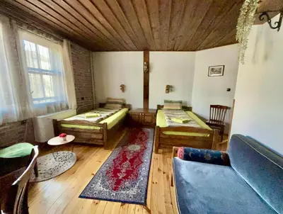 a living room with two beds and a couch at Семеен хотел-ресторант Маламовата къща in Gotse Delchev