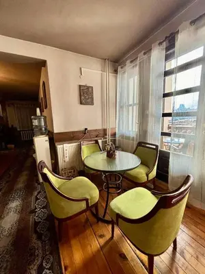 a room with a table and chairs and a window at Семеен хотел-ресторант Маламовата къща in Gotse Delchev