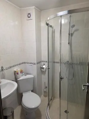 a bathroom with a shower and a toilet and a sink at TMF Mountain Lodge Cozy Studio apartment in Pamporovo