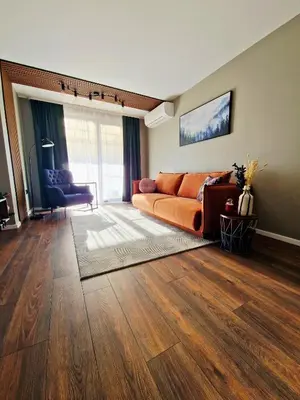 a living room with an orange couch in a room at By The Pool Apartments #7 in Velingrad
