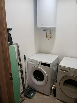 a laundry room with a washing machine and a cabinet at Raya - Apartmant in Plovdiv, with private parking in Plovdiv