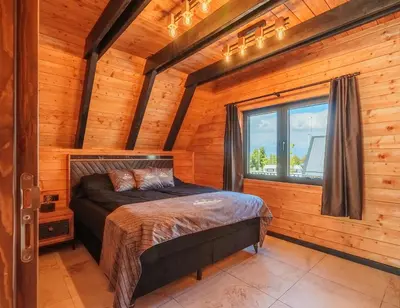 a bedroom with a bed in a log cabin at Camping Between the Mountains Bansko in Bansko