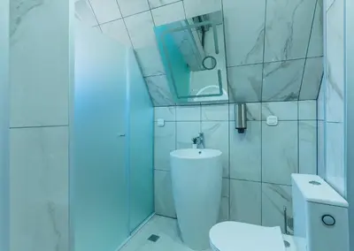 a white bathroom with a toilet and a mirror at Camping Between the Mountains Bansko in Bansko