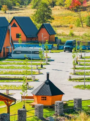 an orange building in a parking lot with houses at Camping Between the Mountains Bansko in Bansko