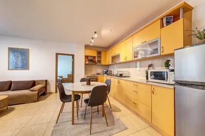 a kitchen and living room with a table and chairs at Two-bedroom Apartment in the Heart of the Rhodopes in Pamporovo