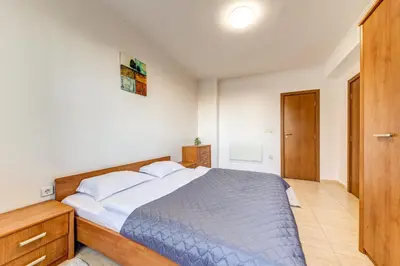 a bedroom with a bed and a wooden cabinet at Two-bedroom Apartment in the Heart of the Rhodopes in Pamporovo
