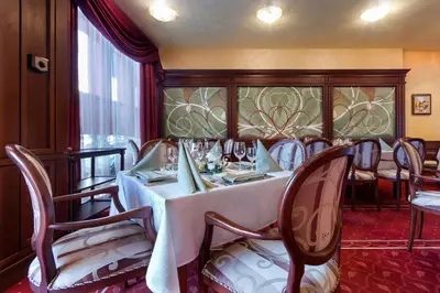 a dining room with a white table and chairs at Hotel Chiirite in Plovdiv
