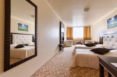 a hotel room with two beds and a mirror at Hotel Chiirite in Plovdiv